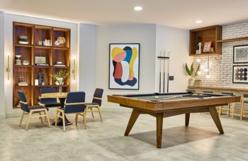 a living room with a pool table and a dining table
